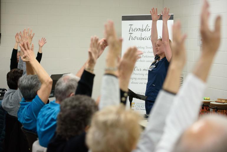 Photo of seniors with hands raised