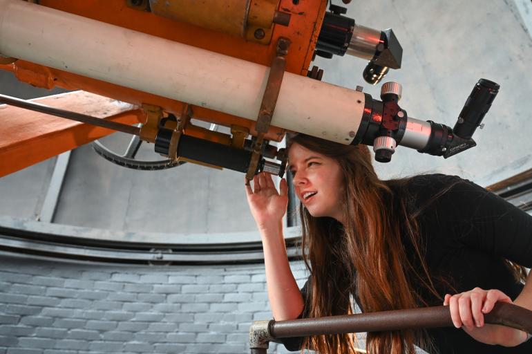 Student looking into a telescope