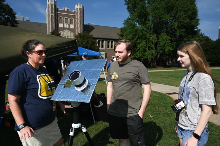 Students looking at a telescope project