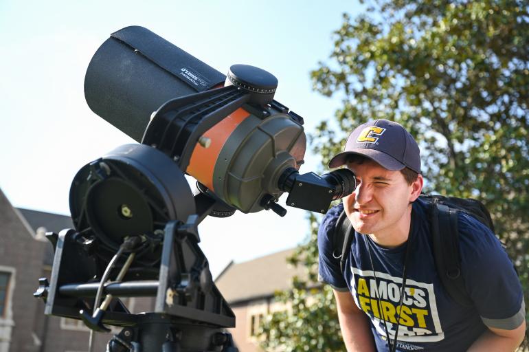 Student using a telescope during the day