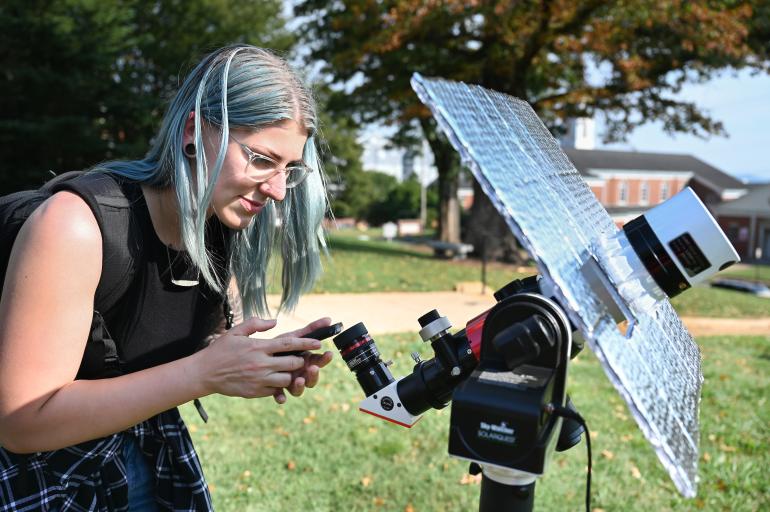 Student adjusting telescope
