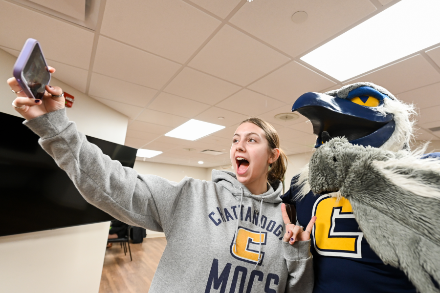 Female student taking a selfie with Scrappy