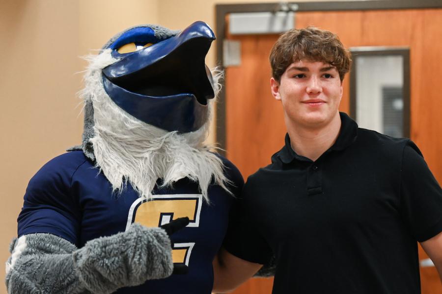 Visit UTC UTC student standing next to Scrappy