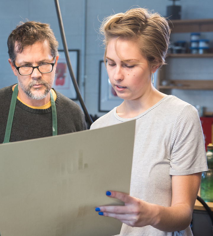 faculty-staff woman showing man something on a poster