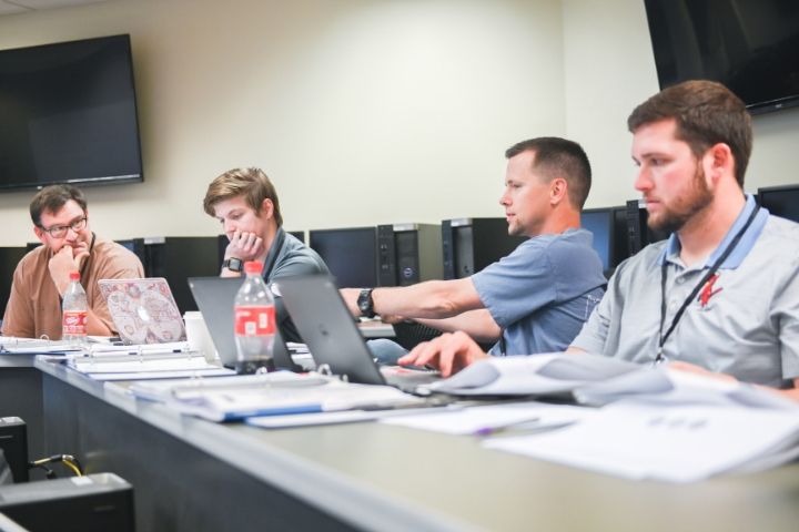 Men sitting at desk discussing