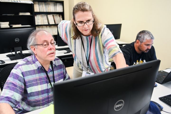 professor helping two students at computers