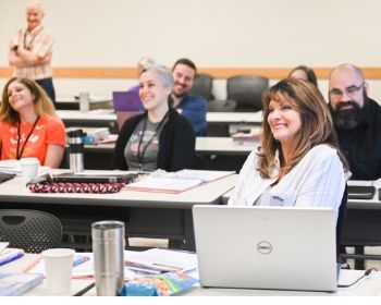 How to enroll bookkeeping A group of participants smiling and listening to a lecture.