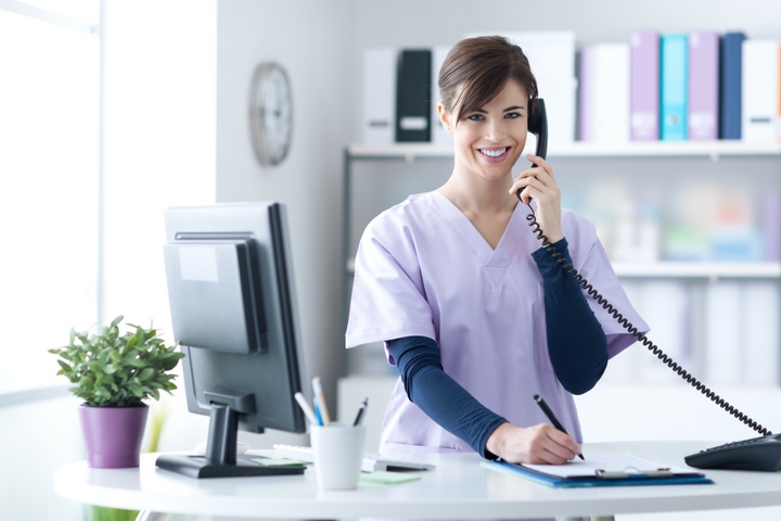 Women in scrubs on the phone at desk