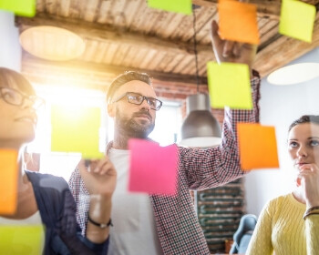 Group of people wondering how they got sticky notes to float