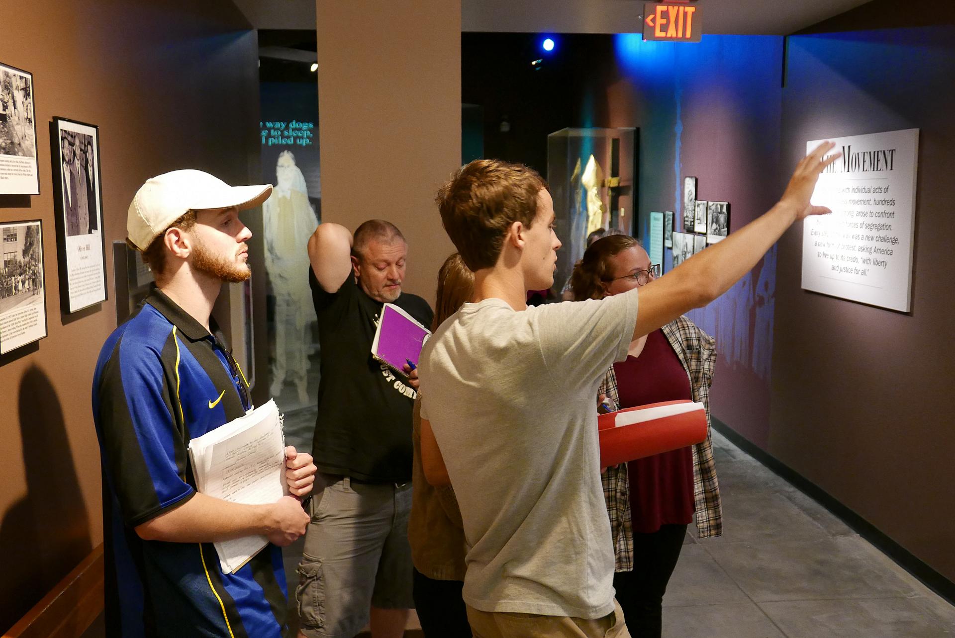 Students observing an exhibit at a museum