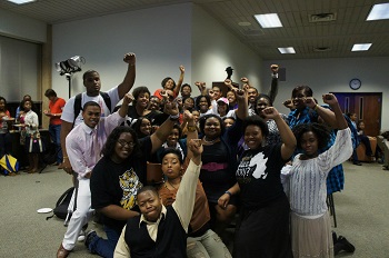group of people posing for a picture with the black power fist