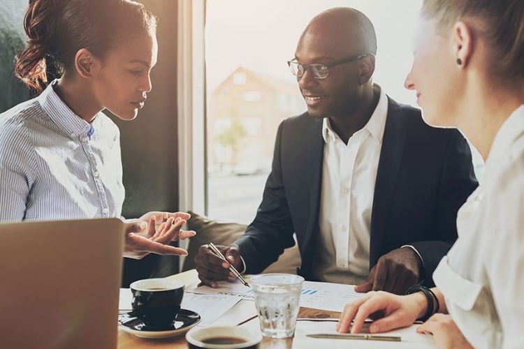 A group of people sitting around a table discussing a project plan.