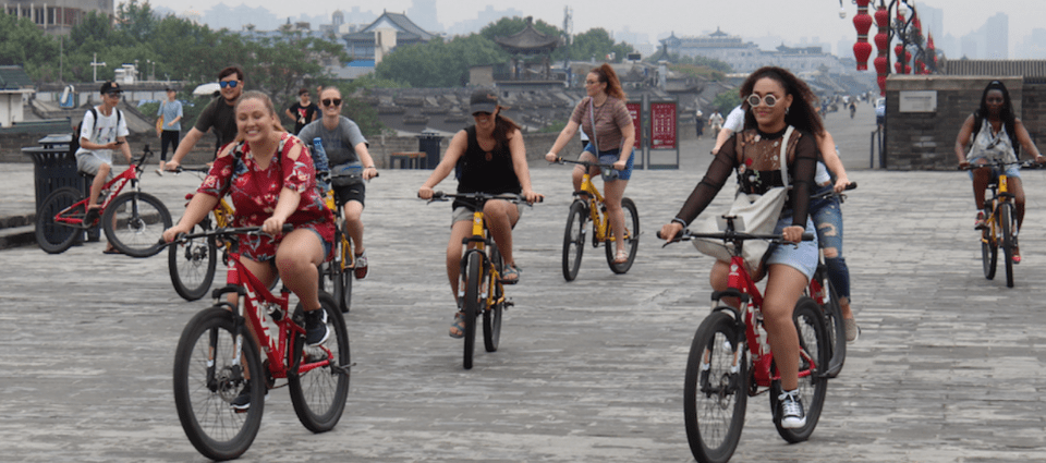 UTC Geography students bicycling across a plaza, during a trip to China