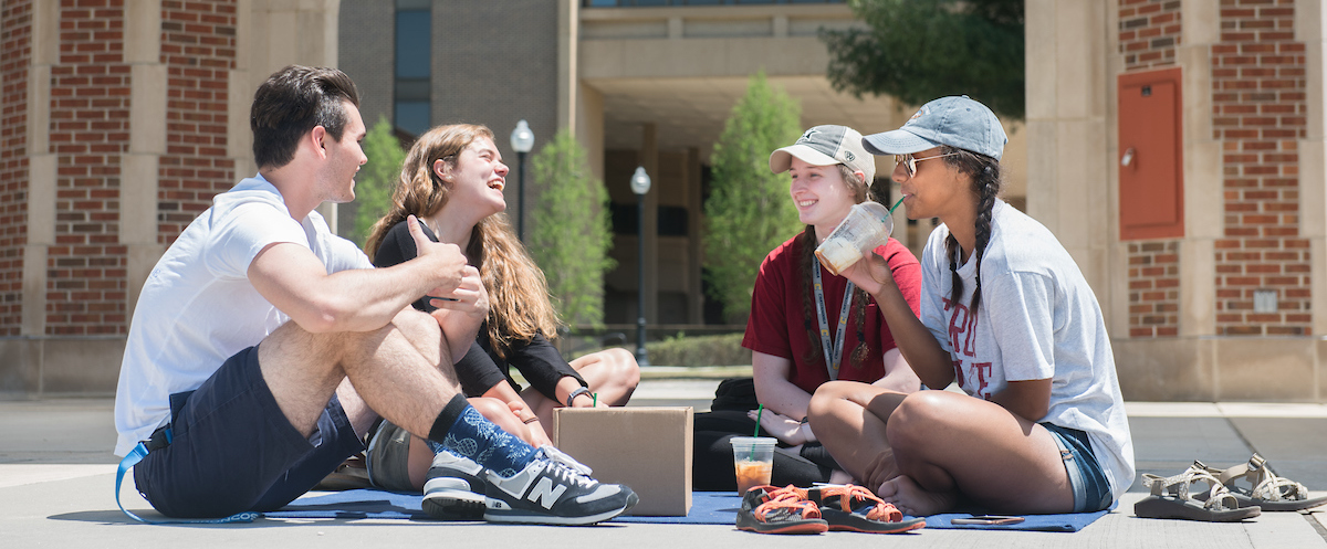 Four students sitting outside