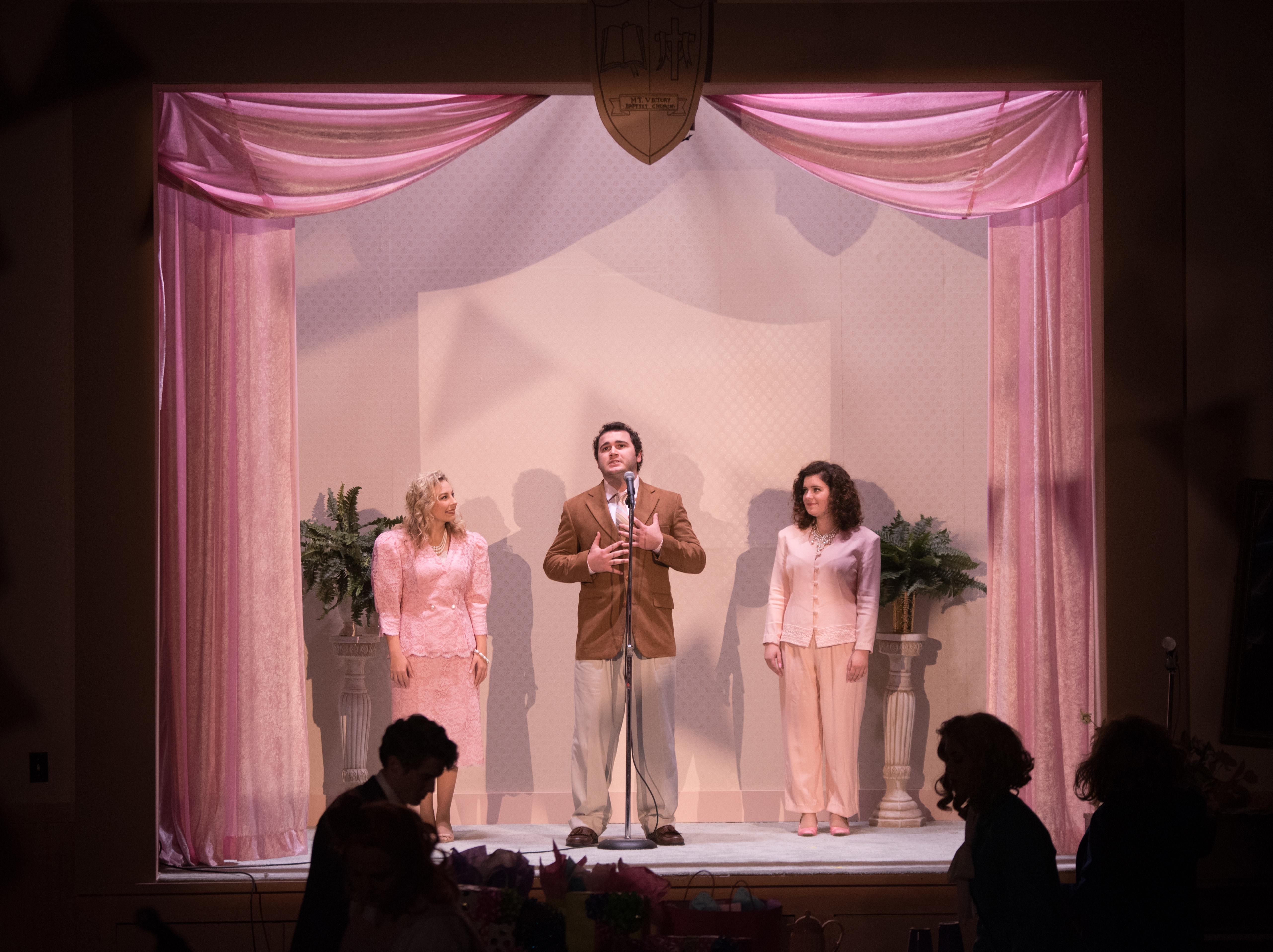 cast members perform on a set made to look like a stage