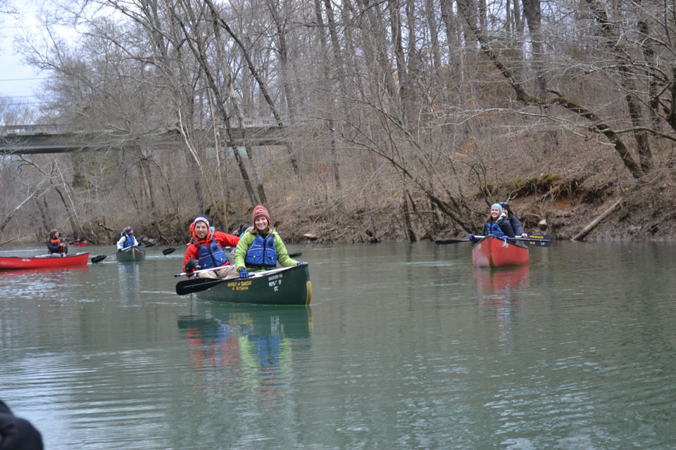 People in kayaks and canoes on a river