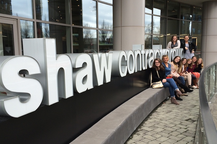 shaw contractors sign with students sitting on it