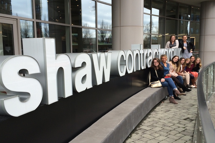 Study Tours Courses Page shaw contractors sign with students sitting on it