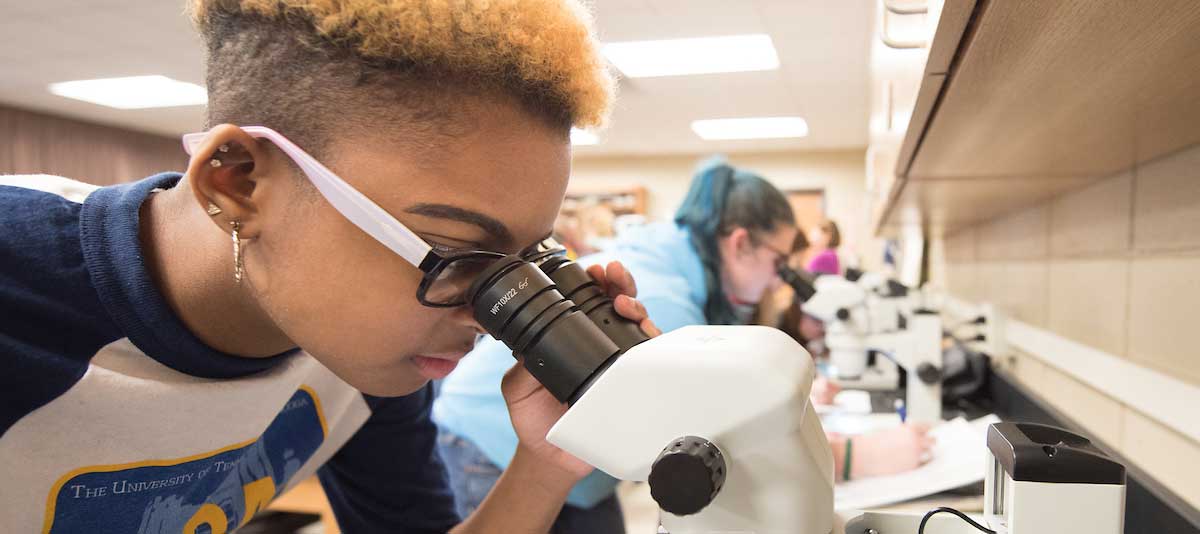 Female looking in microscope