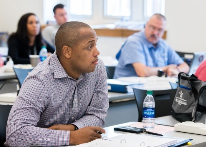 An individual sitting in a class listening to a lecture