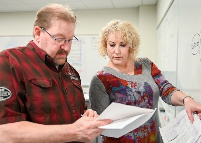 Kimberly Casperson, PMP Instructor, helping a student work a problem at a whiteboard