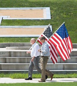 Two men carrying American Flags
