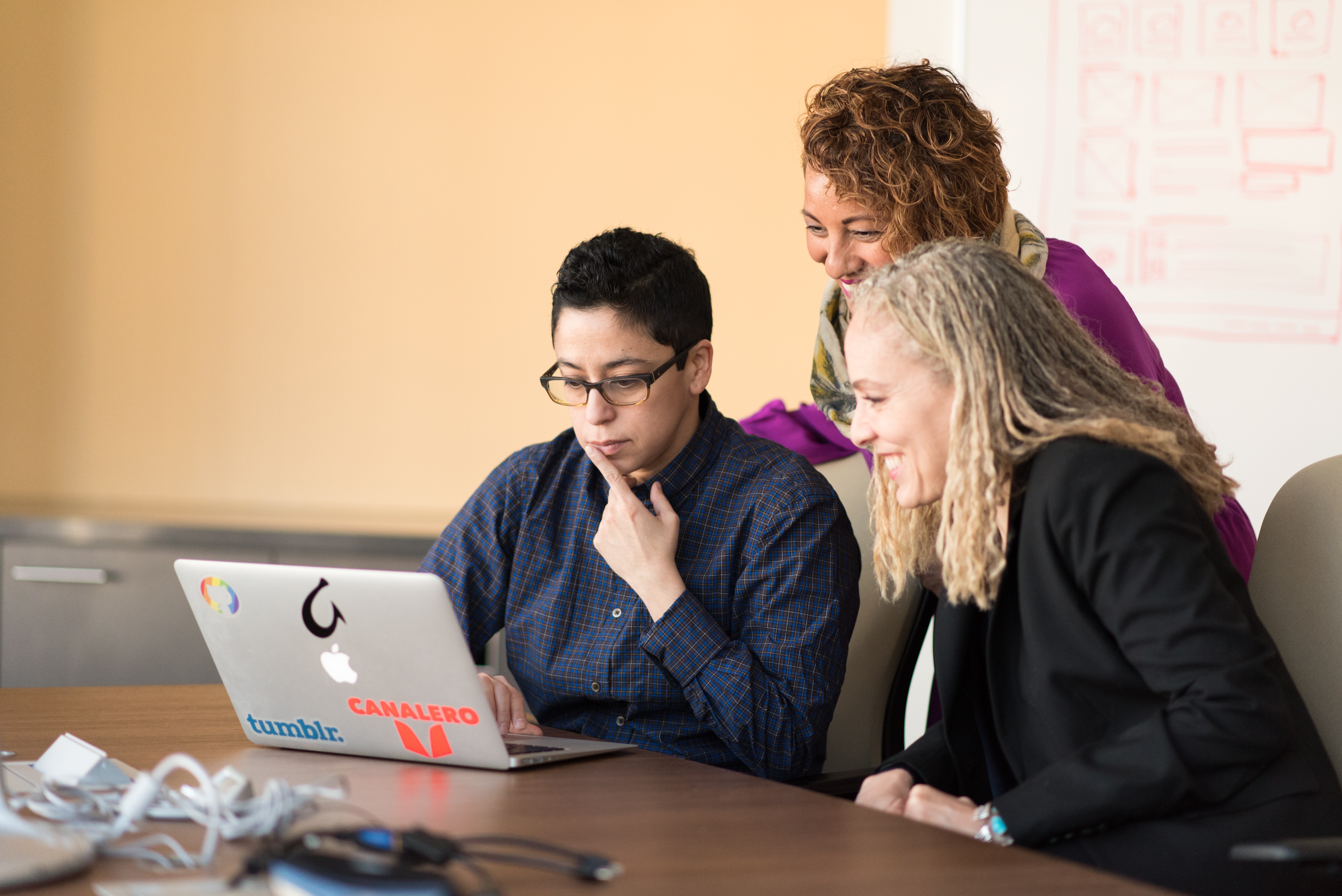 professionals gathered around a macbook