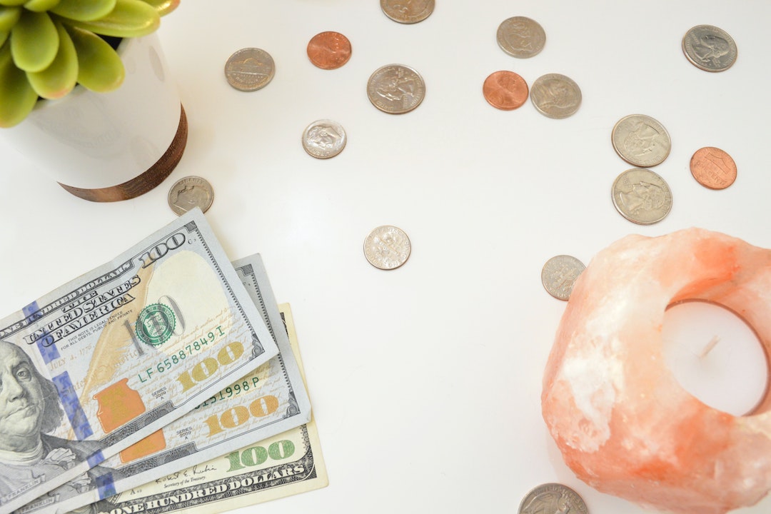 coins and cash on a white desk