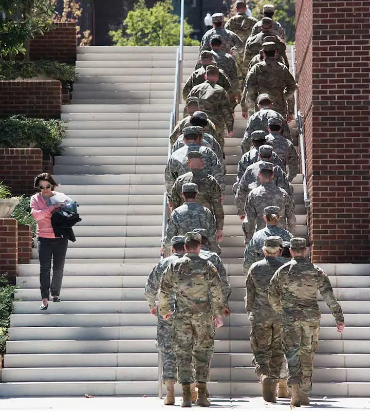 students in military uniforms climbing stairs