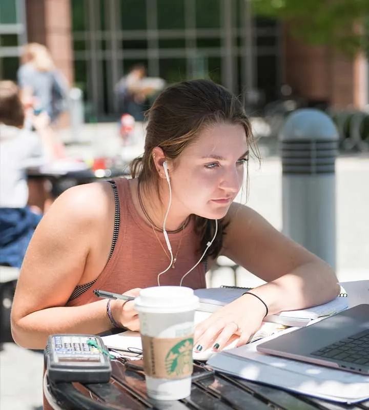 young woman studying in the library courtyard