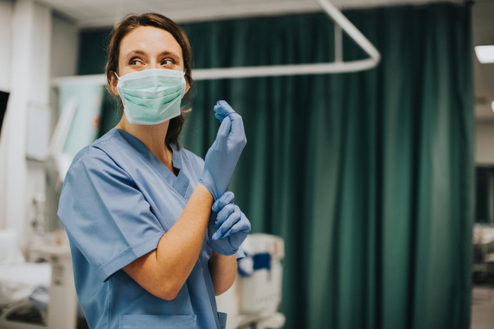 female nurse putting on gloves