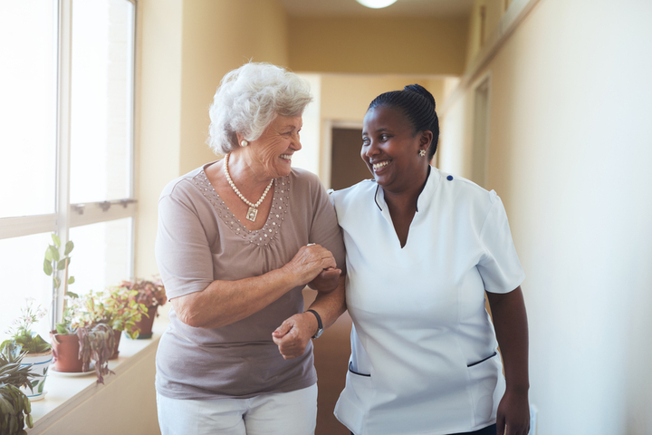 Female CNA Helping Patient as They Walk