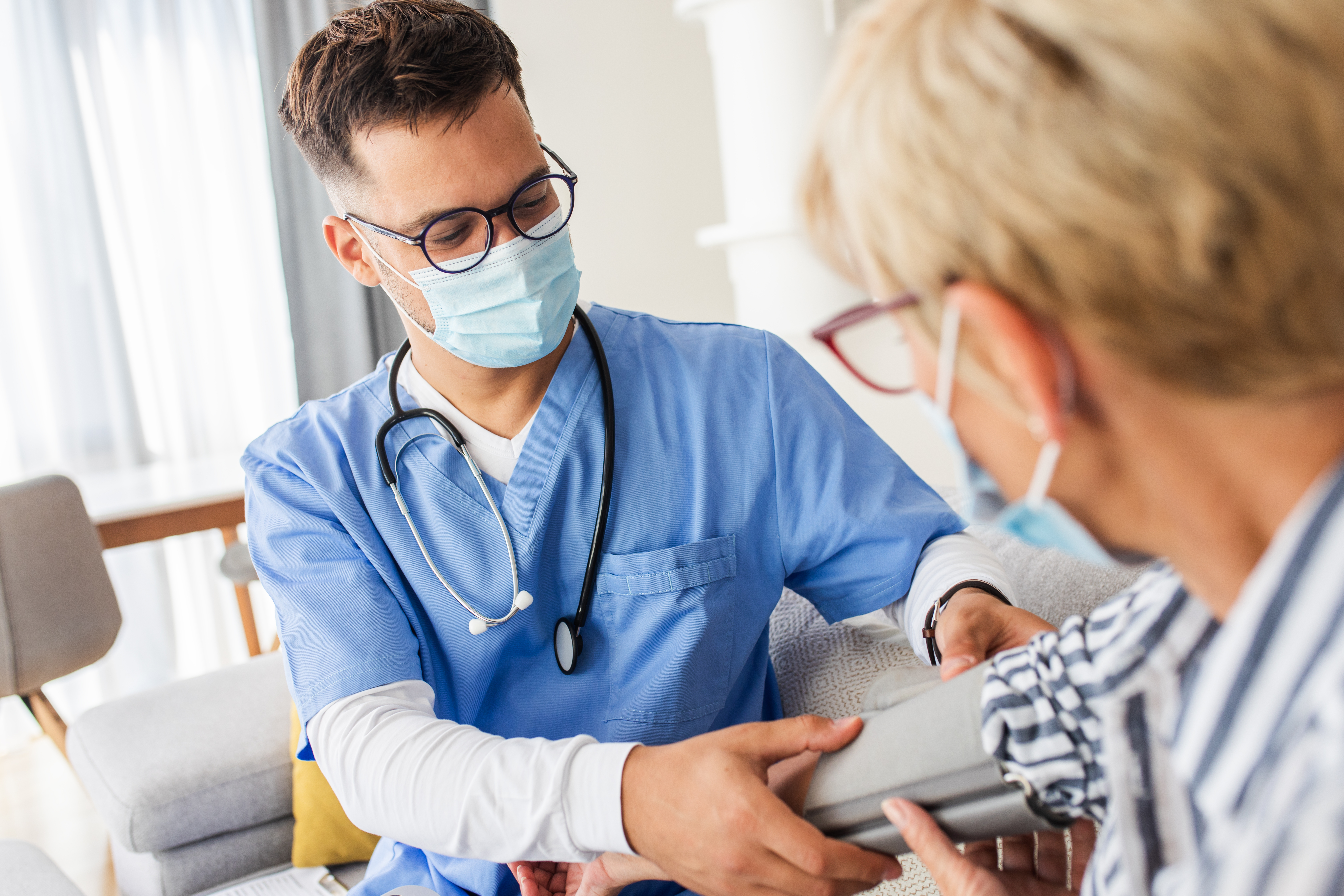 male CNA taking blood pressure