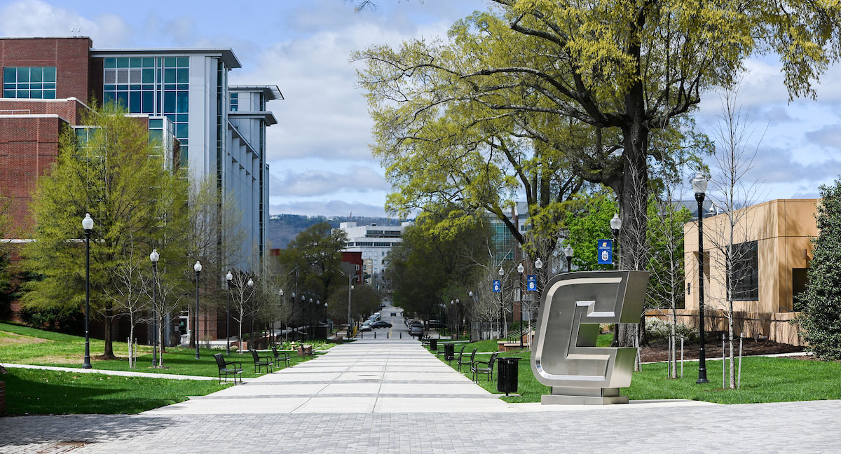 Silver Power C on Campus A view of the tree-lined Vine Street Pedestrian Mall on the UTC Campus, including the stainless-steel "Power C" logo sculpture, Derthick Hall and the UTC Library, with the Unum building in the background.