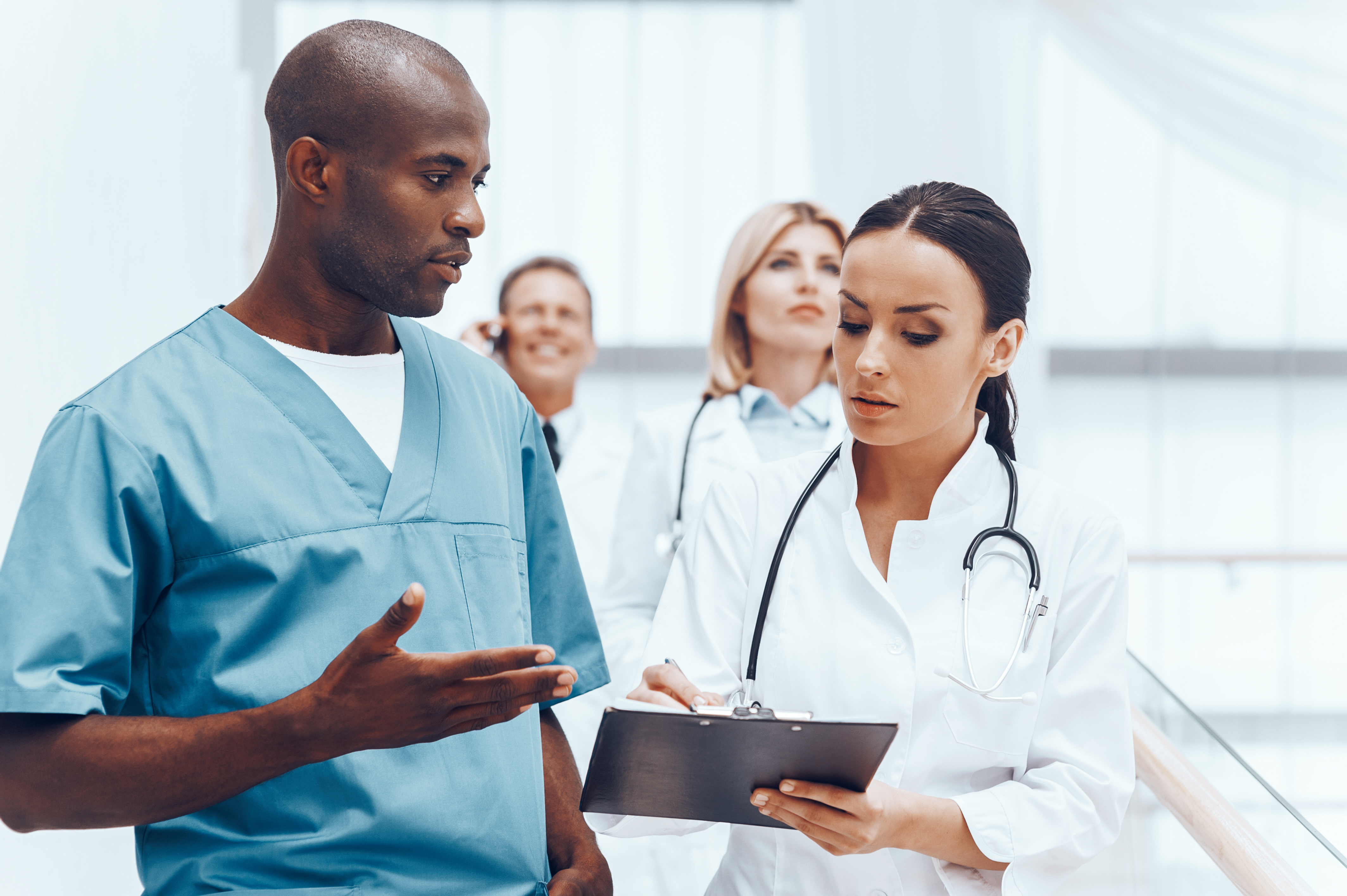 Clinical Medical Assistant male nurse talking to female doctor
