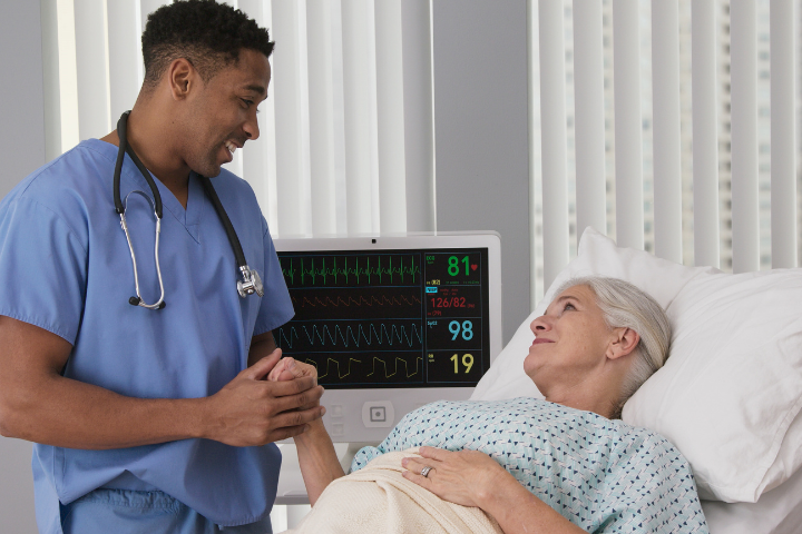 Clinical Medical Assistant male nurse holding male patient's hand
