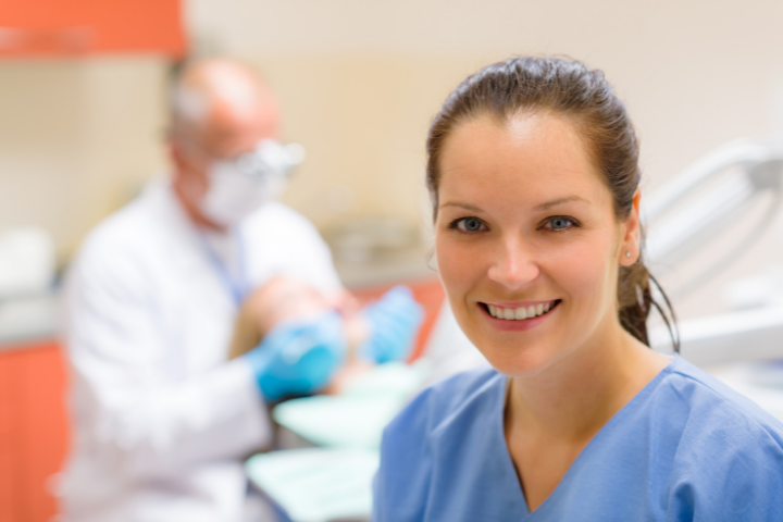 nurse smiling with doctor in background