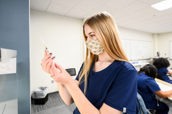 blonde female student looking at a valve