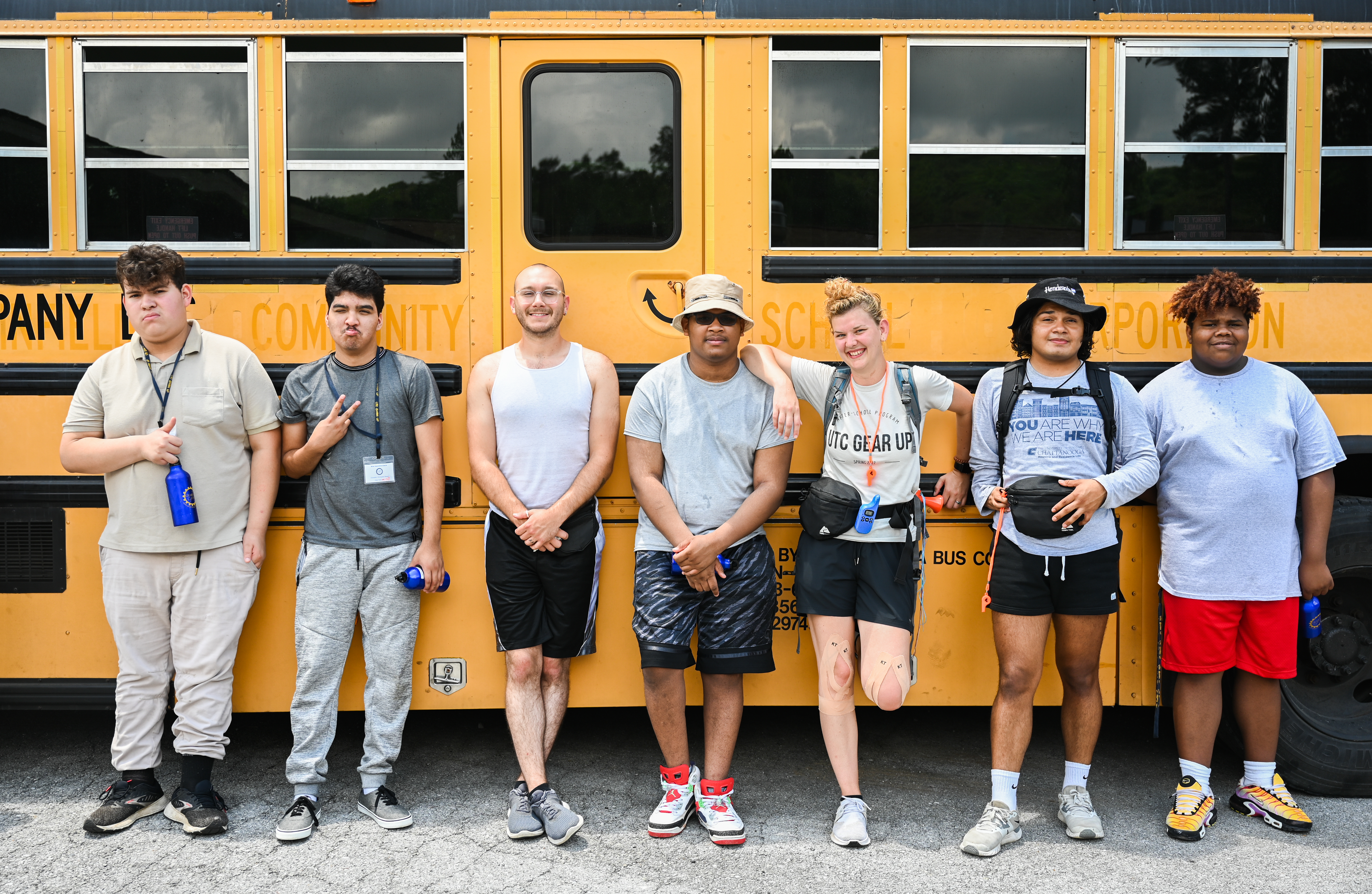 Students posing in front of bus