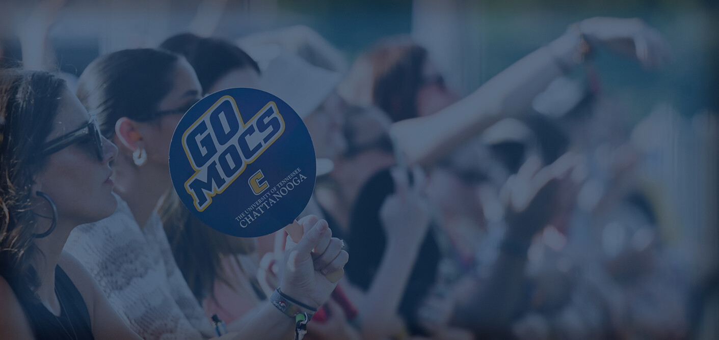 Group of fans at Riverbend Festival. One person holding up a "Go Mocs" sign