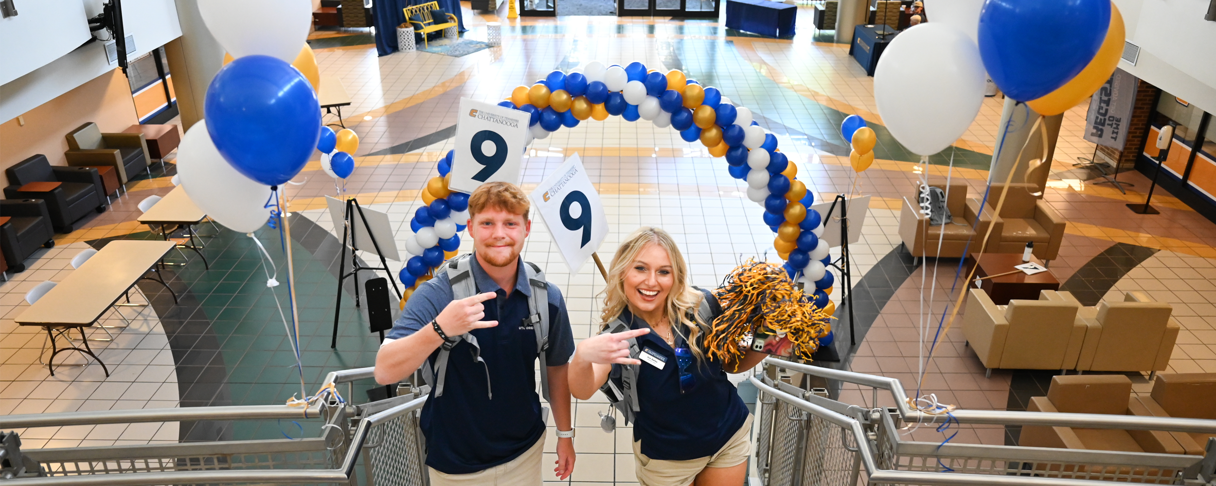 Two orientation leaders standing in front of a balloon arch