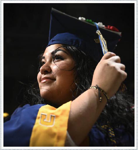 A close up of a young hispanic student turning her tassel upon graduating from UTC.