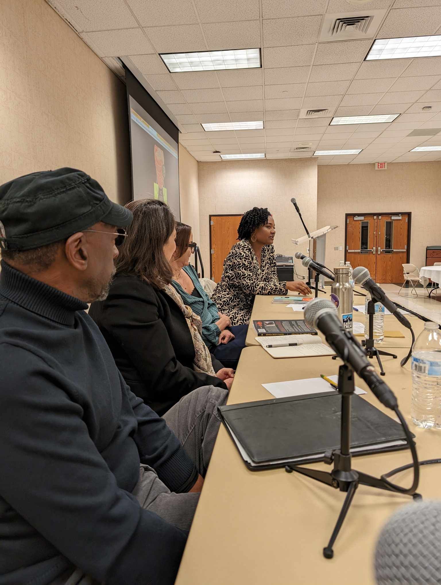 Side view of panelists Braggs, Cummiskey, Palmer, and Author Kesha Ajọsẹ Fisher  at Crossing Lines interdisciplinary conversation