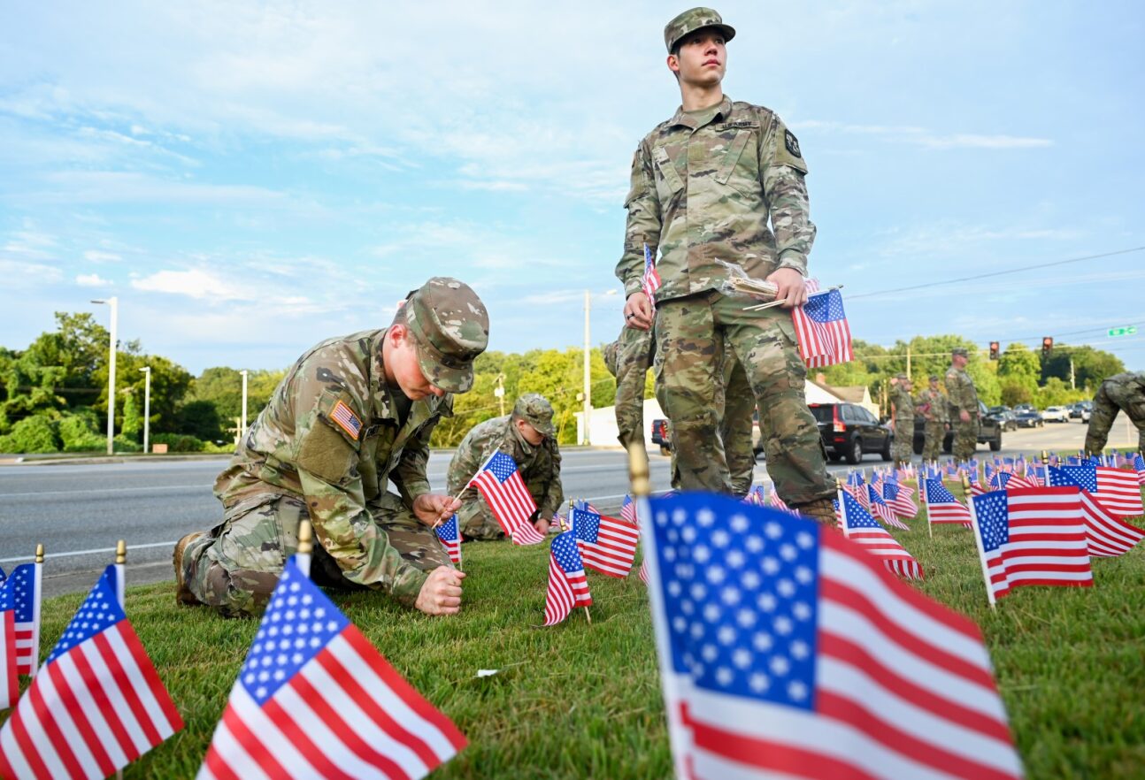 cadets putting small american flags in the ground