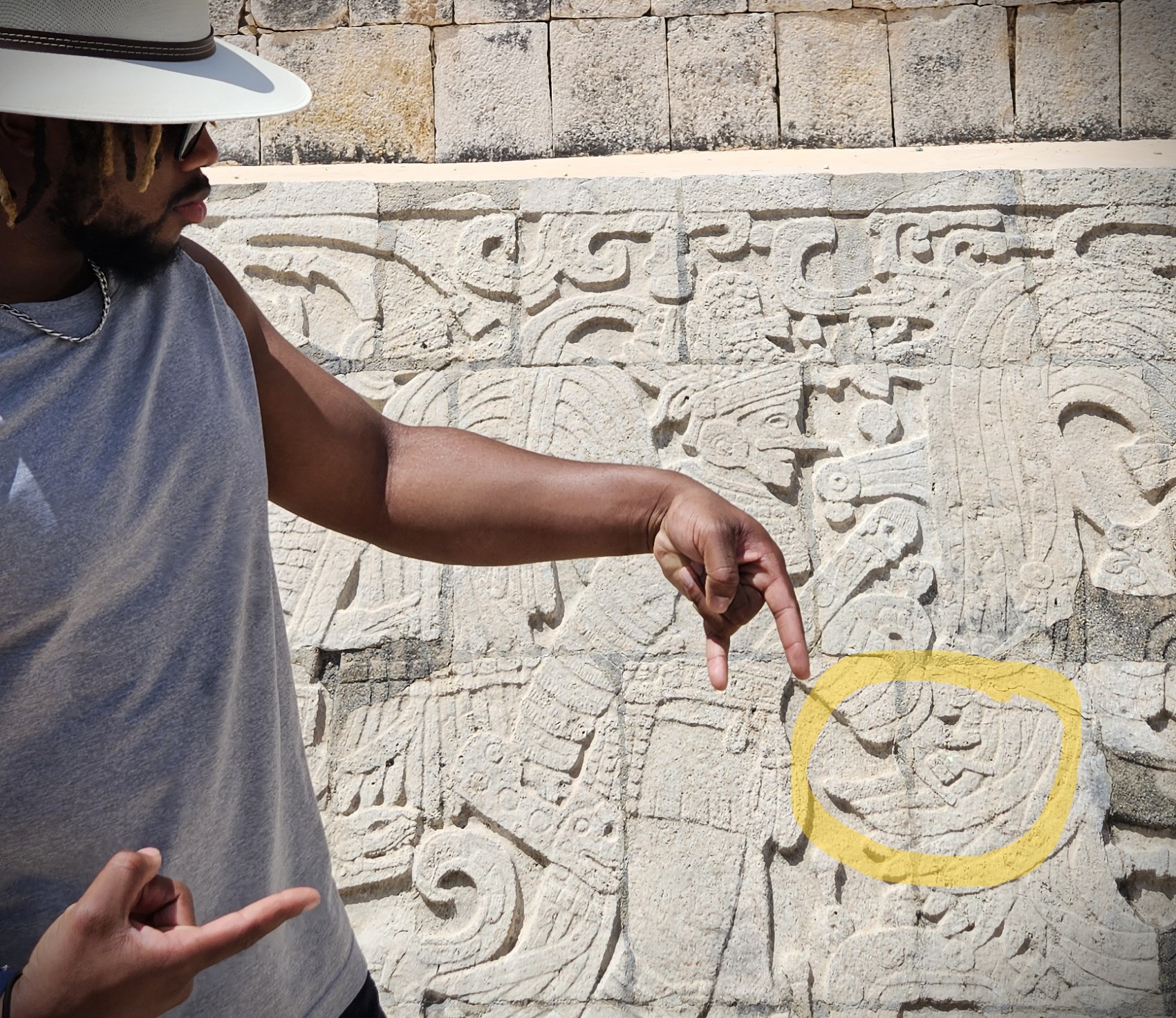 A&SRC Explorer discovers evidence that the ancient Maya knew the Power C! Student poses in front a hieroglyph  resembling the Power C in Chichen Itza