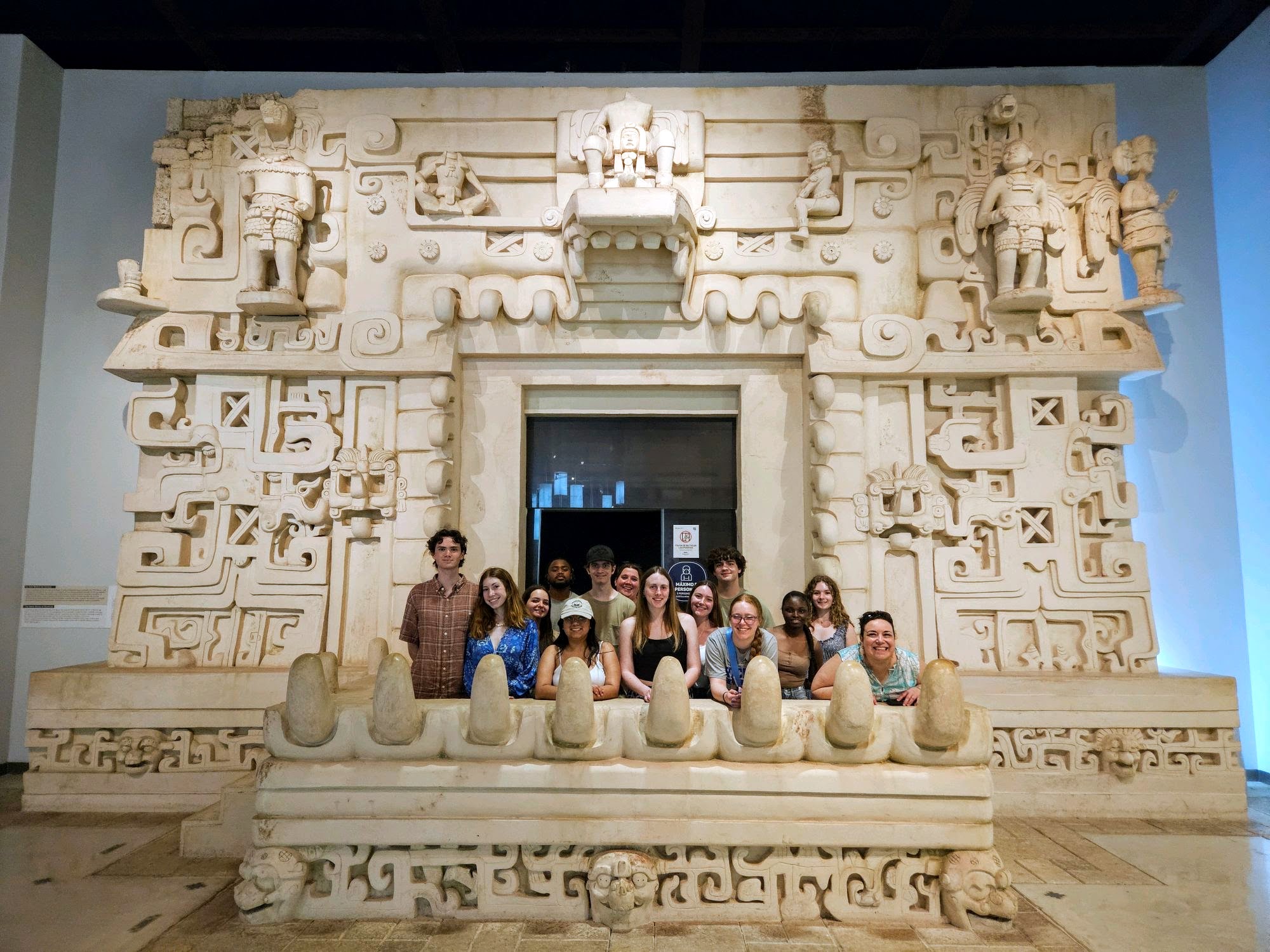 Students pose for a photo at an exhibit in the Great Museum of the Mayan World.