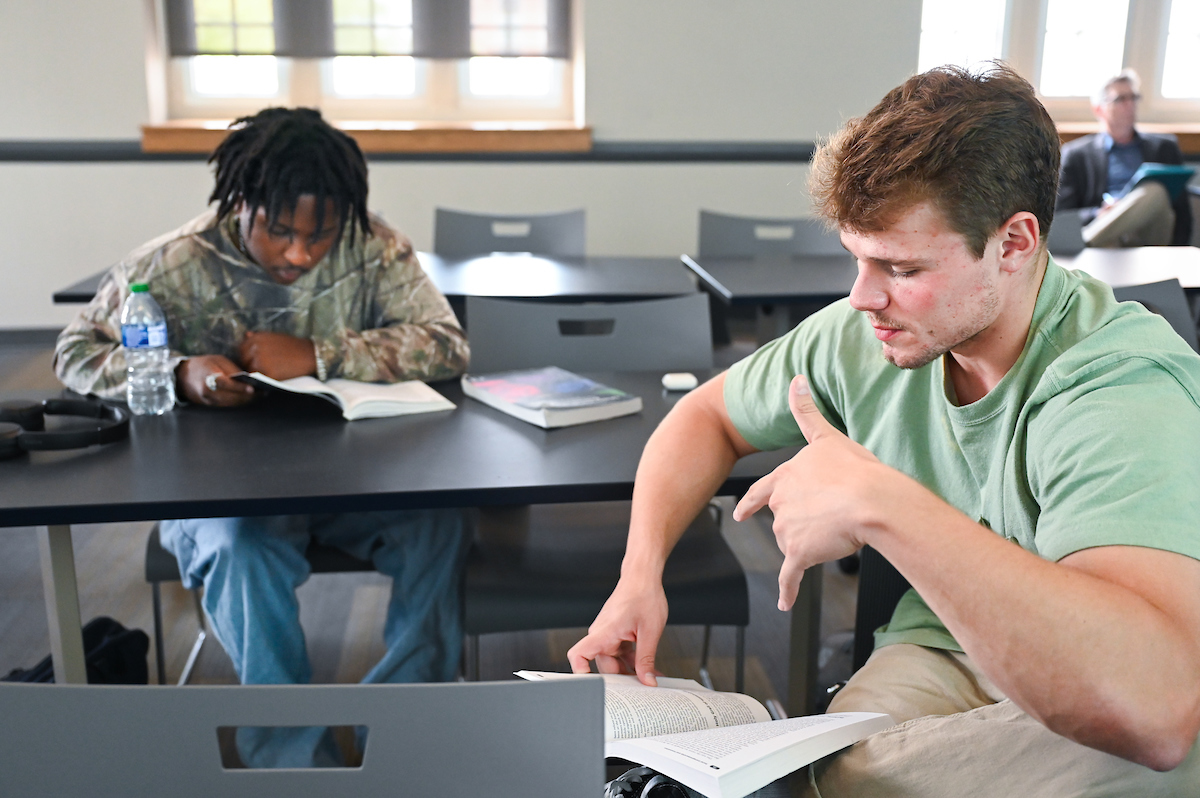 Class in fletcher Students reading a book together in class