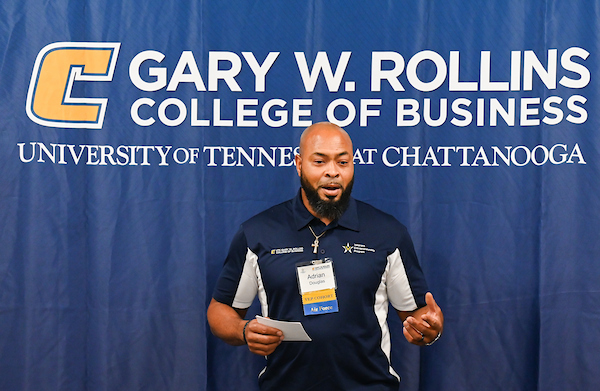 VEP presentation VEP student standing in front of backdrop for Gary W Rollins College of Business giving a presentation