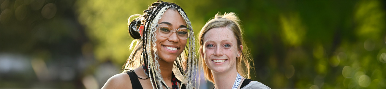 UTC general enrollment two utc students smiling in front of a blurred green background