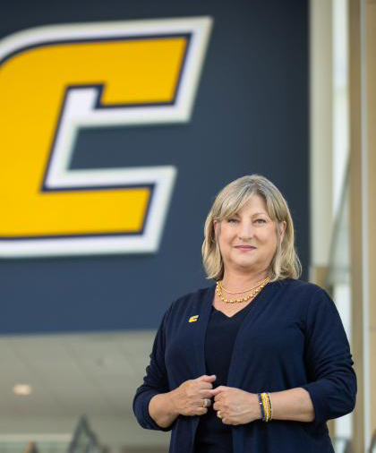 Chancellor Lori Bruce in front of a power C banner